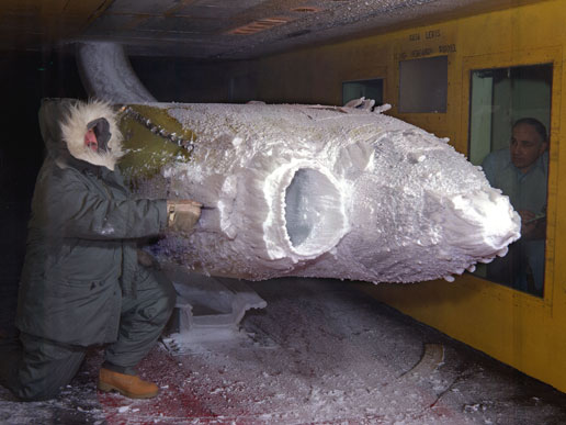 Workers observe as a commuter transport engine undergoes testing in the Icing Research Tunnel.