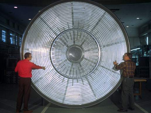 Scientists stand in front of the aeroshell that protected the Viking Lander I during its entry into the Martian atmosphere.