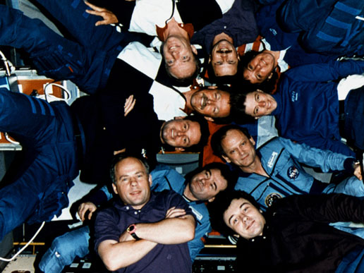 Inside the Spacelab Science Module, the crews of STS-71, Mir-18 and Mir-19 pose for the traditional inflight picture.